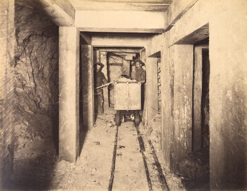 Mt Con 100 level East sill floor.  Showing miners in ore breast filling ore cars. Ore 12 ft.