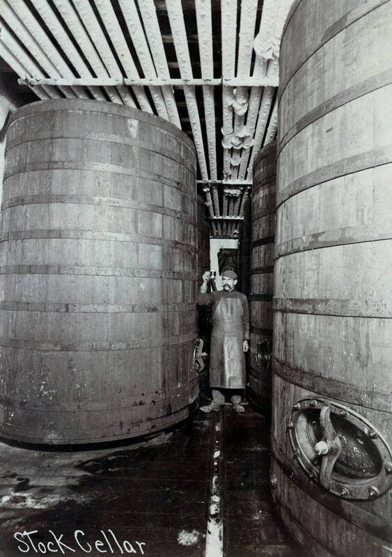 Brew master is checking contents of large aging vats
