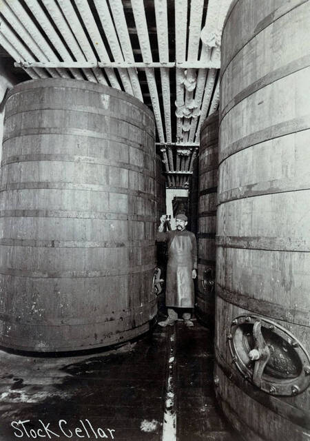 Brew master is checking contents of large aging vats