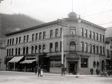 Doctor C.R. Mowery and H.C. Mowery and dental offices upstairs. Also based in building are the Kozy Korner Rooms, Wallace Drug Co., Solberg's Men's Furnishings, and Gibb Jewelry store.