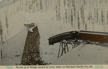 Postcard of a wreck on a railroad trestle caused by a snow slide.